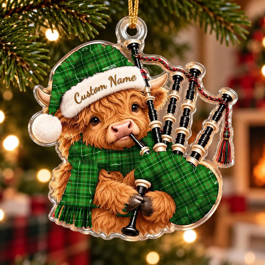 Acrylic Highland cow calf ornament playing the bagpipes, in a Blane 1 tartan Santa hat, scarf and pipe bag, with a custom name on the hat