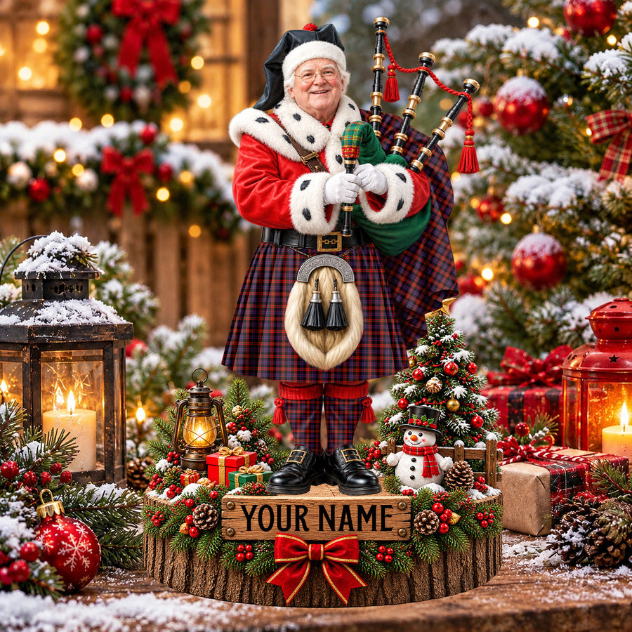 Personalized Christmas piper plaque in the Broun tartan, standing on a snowy log base with a name plaque
