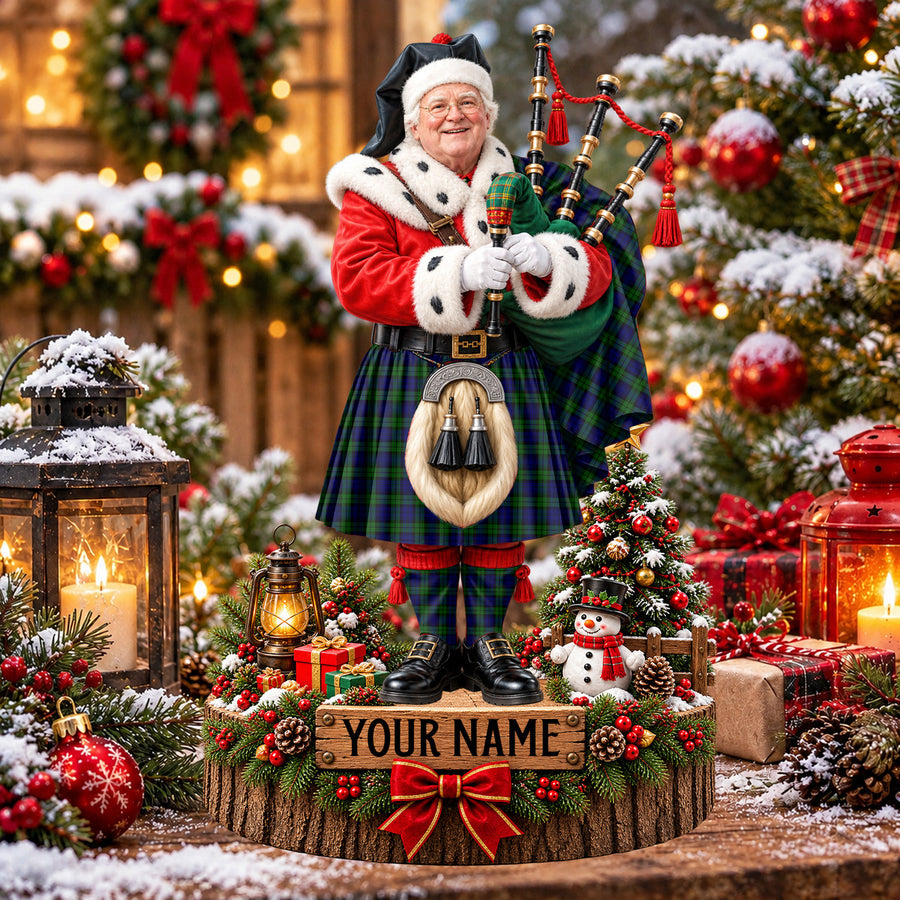 Personalized Christmas piper plaque in the Campbell Modern tartan, standing on a snowy log base with a name plaque