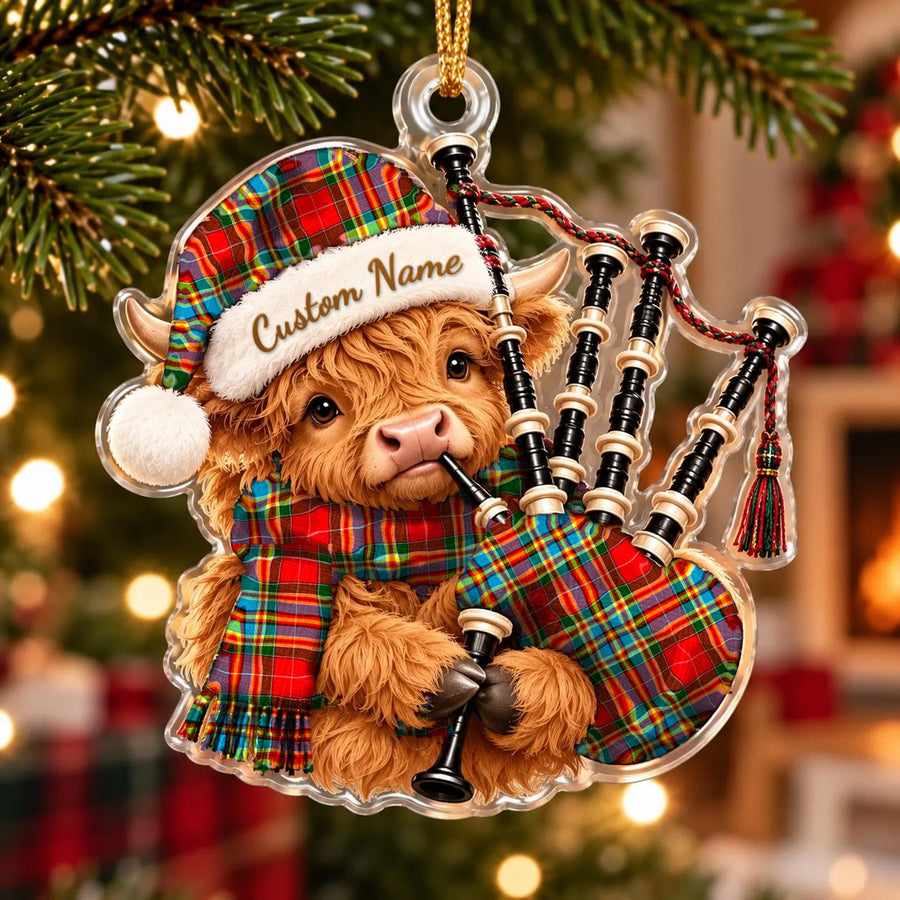 Acrylic Highland cow calf ornament playing the bagpipes, in a Chattan tartan Santa hat, scarf and pipe bag, with a custom name on the hat