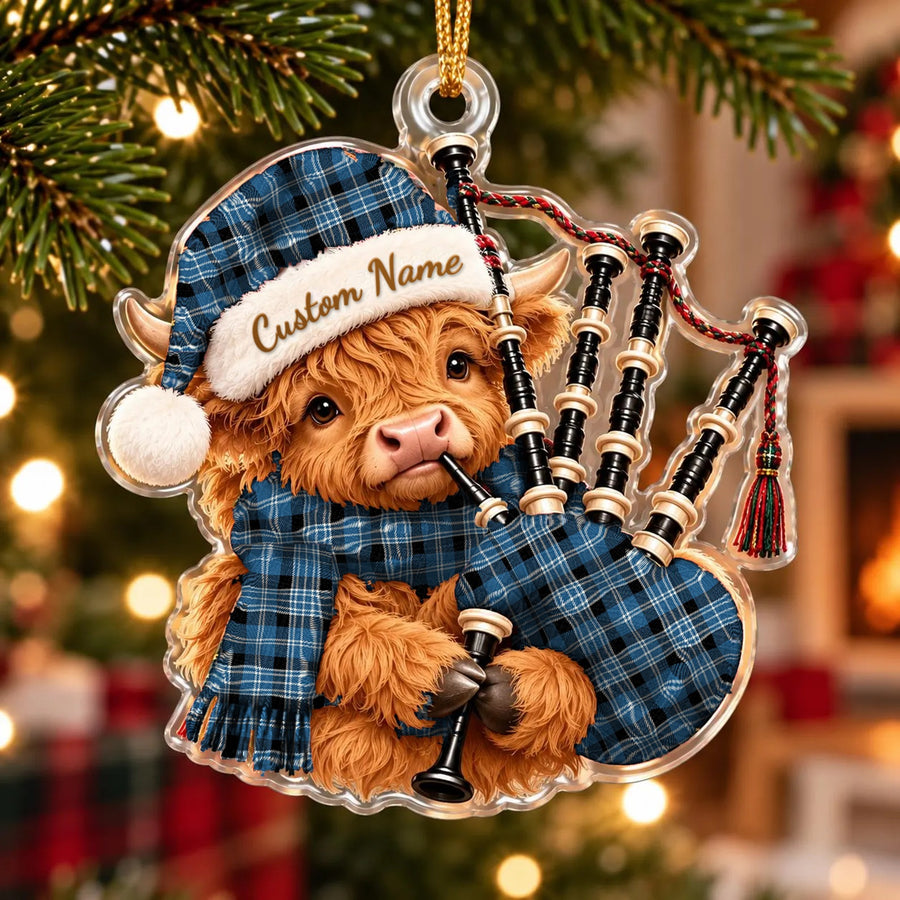 Acrylic Highland cow calf ornament playing the bagpipes, in a Clark Ancient tartan Santa hat, scarf and pipe bag, with a custom name on the hat