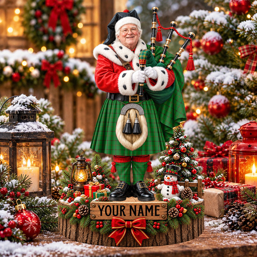 Personalized Christmas piper plaque in the Don (Tribe-of-Mar) tartan, standing on a snowy log base with a name plaque