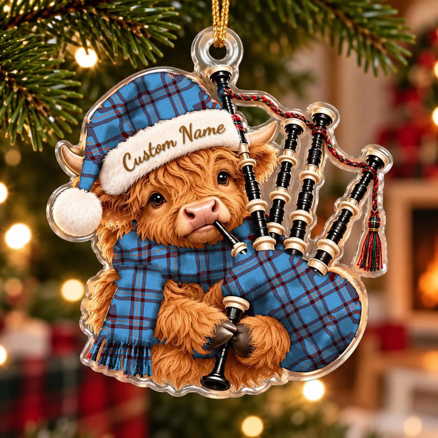 Acrylic Highland cow calf ornament playing the bagpipes, in a Elliot Ancient tartan Santa hat, scarf and pipe bag, with a custom name on the hat