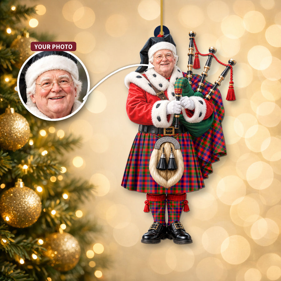 Christmas piper ornament in the Gow Modern tartan hanging on a Christmas tree, with the customer photo used for the face