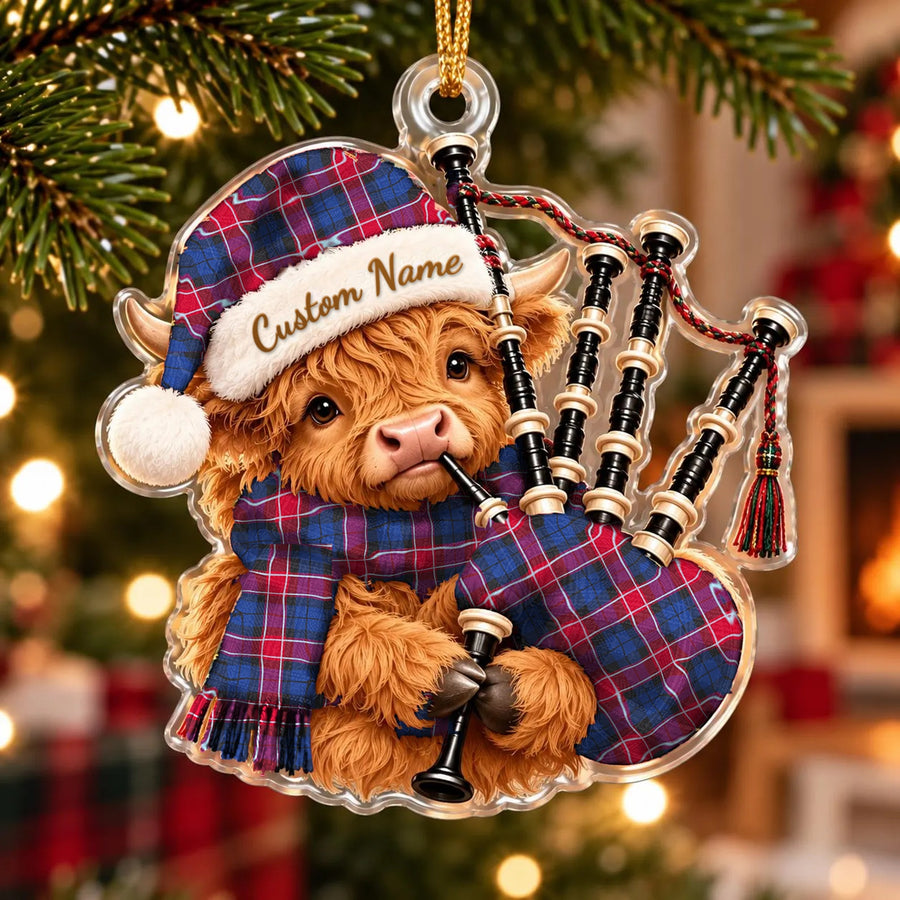 Acrylic Highland cow calf ornament playing the bagpipes, in a Graham of Menteith Red tartan Santa hat, scarf and pipe bag, with a custom name on the hat