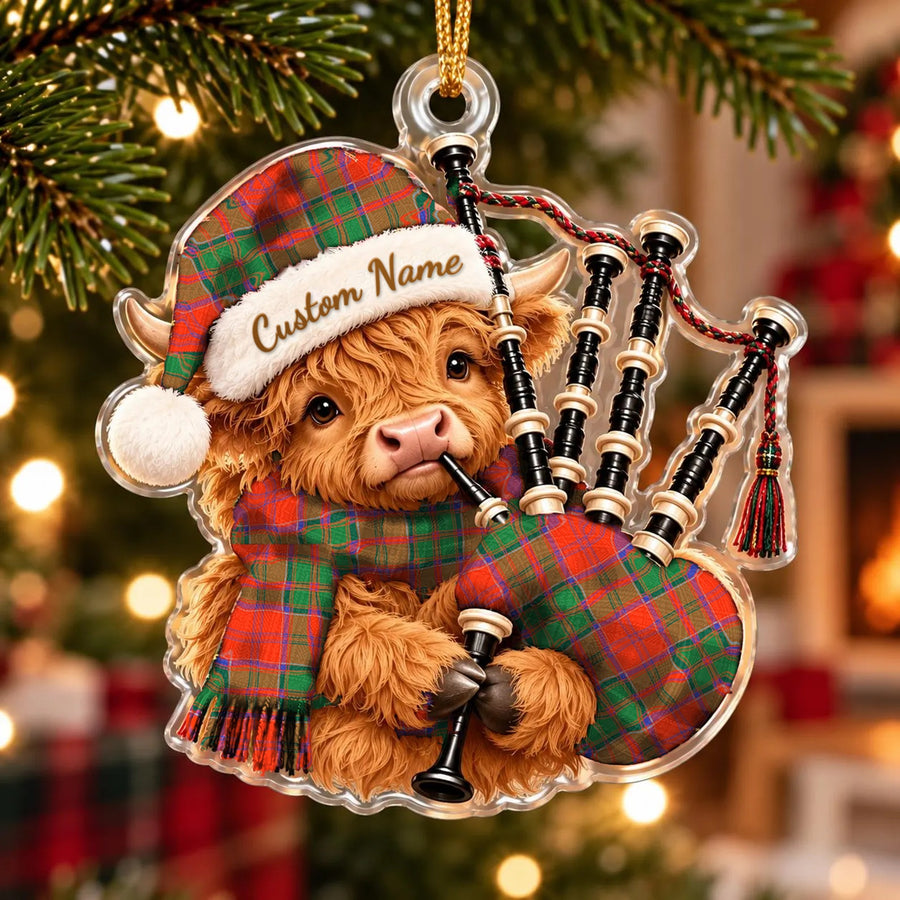 Acrylic Highland cow calf ornament playing the bagpipes, in a Grant Ancient tartan Santa hat, scarf and pipe bag, with a custom name on the hat