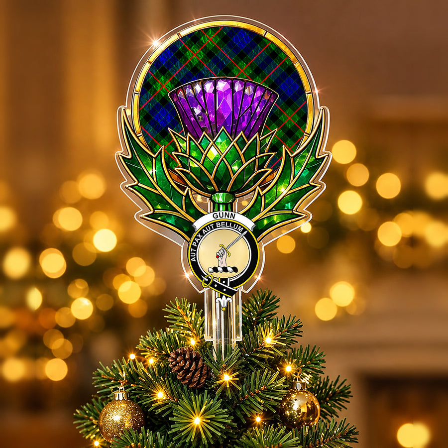 Clan Gunn crest in the centre of a stained-glass style thistle Christmas tree topper with the Gunn Modern tartan behind the thistle