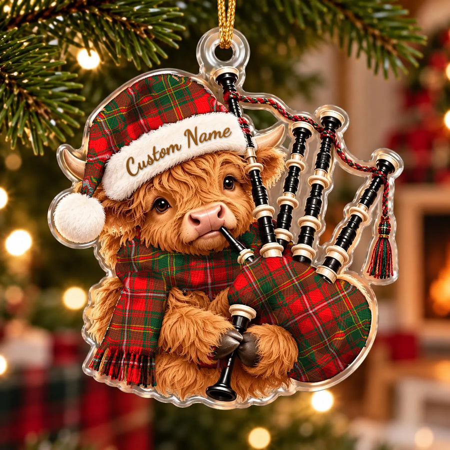 Acrylic Highland cow calf ornament playing the bagpipes, in a Hay Modern tartan Santa hat, scarf and pipe bag, with a custom name on the hat