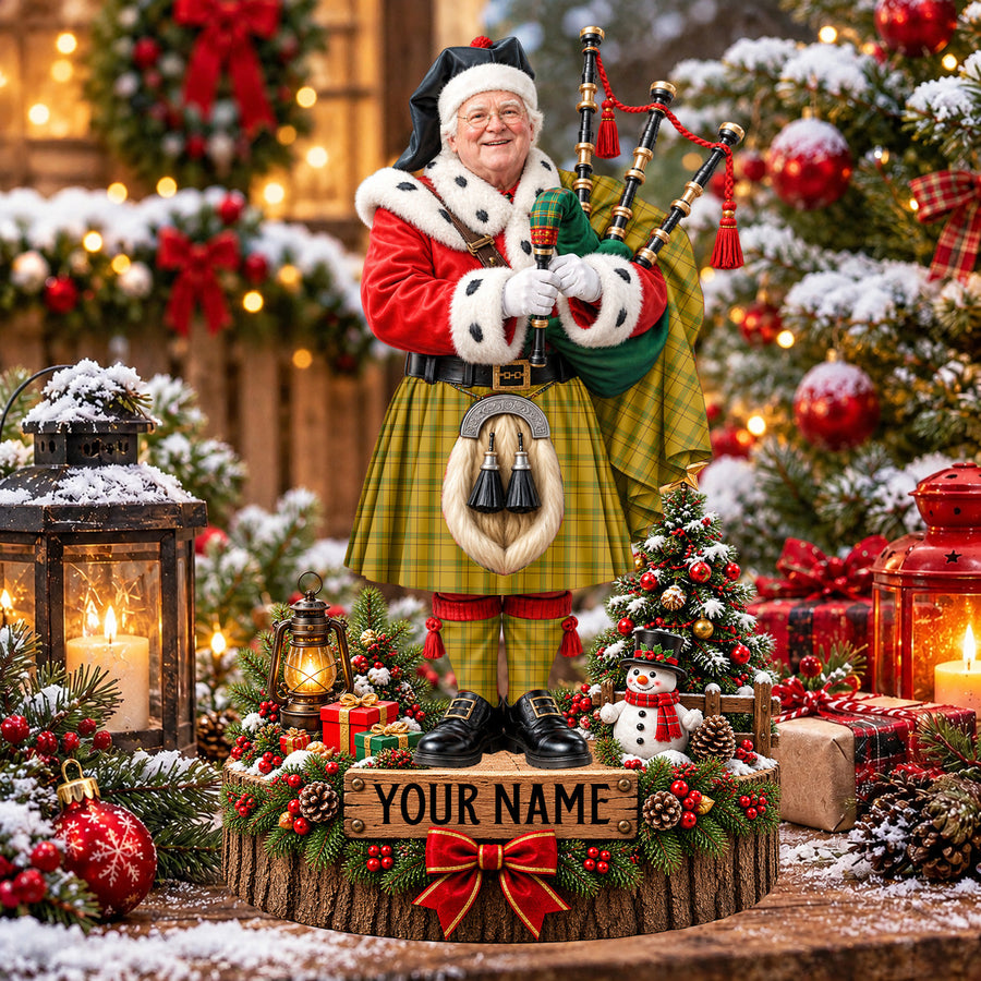 Personalized Christmas piper plaque in the Houston tartan, standing on a snowy log base with a name plaque