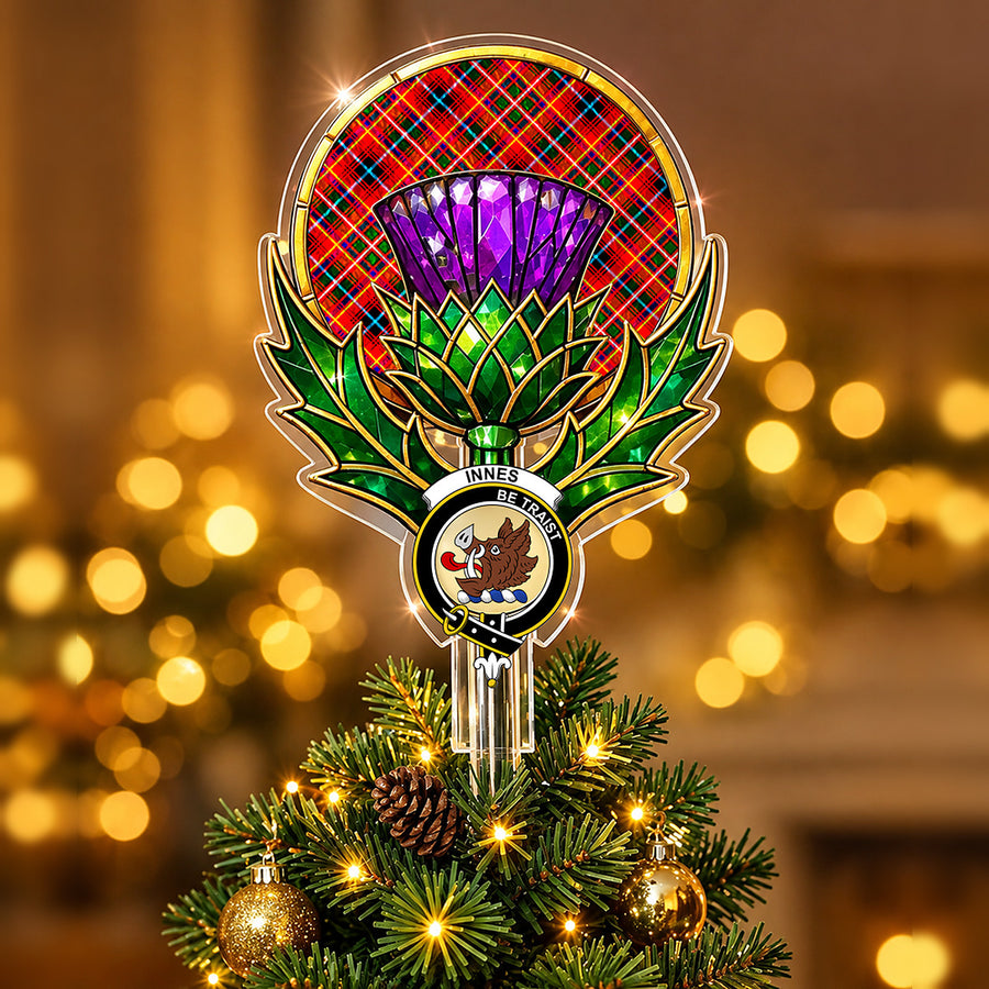 Clan Innes crest in the centre of a stained-glass style thistle Christmas tree topper with the Innes Modern tartan behind the thistle