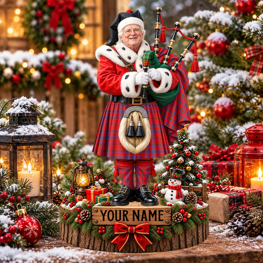 Personalized Christmas piper plaque in the Inverness District tartan, standing on a snowy log base with a name plaque