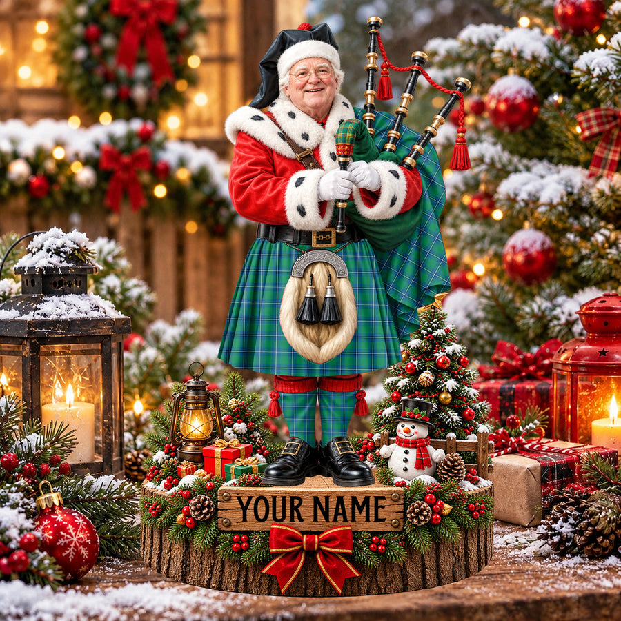 Personalized Christmas piper plaque in the Irvine Ancient tartan, standing on a snowy log base with a name plaque