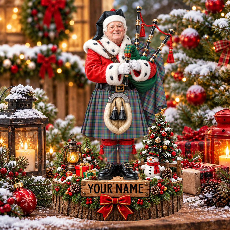 Personalized Christmas piper plaque in the Isle of Skye tartan, standing on a snowy log base with a name plaque