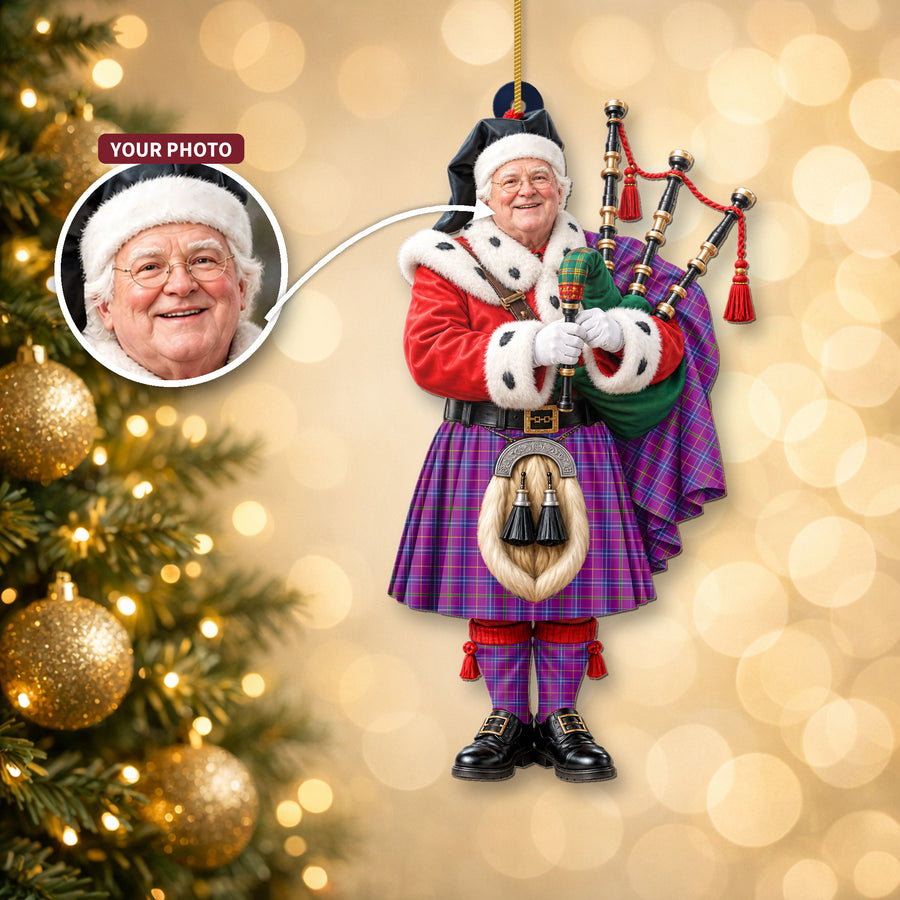 Christmas piper ornament in the Jackson tartan hanging on a Christmas tree, with the customer photo used for the face
