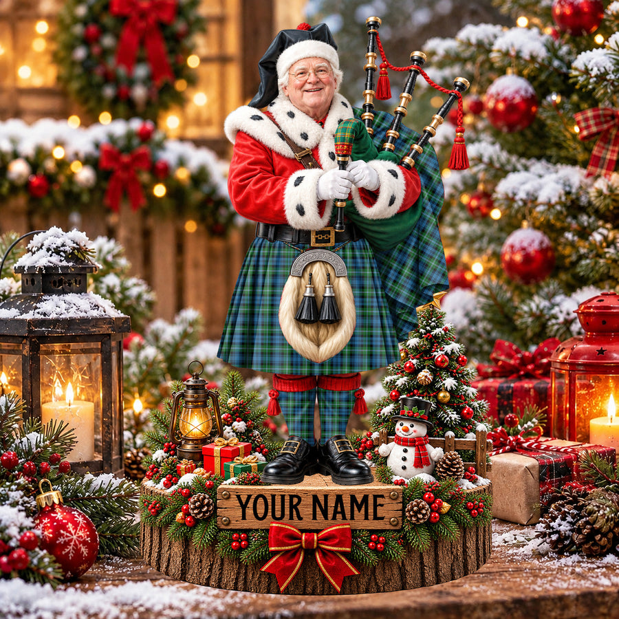 Personalized Christmas piper plaque in the Lyon tartan, standing on a snowy log base with a name plaque
