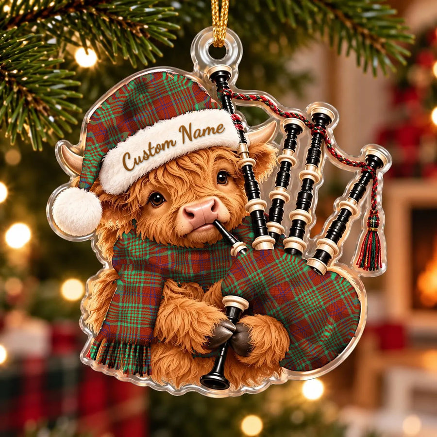 Acrylic Highland cow calf ornament playing the bagpipes, in a MacGillivray Hunting Ancient tartan Santa hat, scarf and pipe bag, with a custom name on the hat