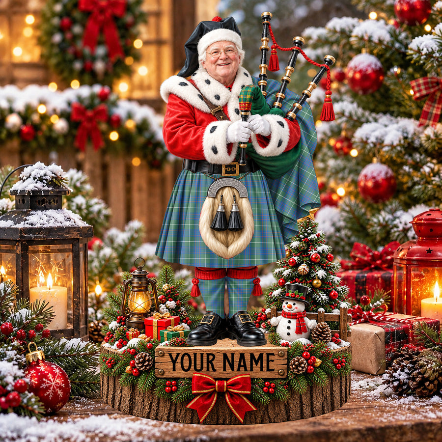 Personalized Christmas piper plaque in the MacIntyre Hunting Ancient tartan, standing on a snowy log base with a name plaque
