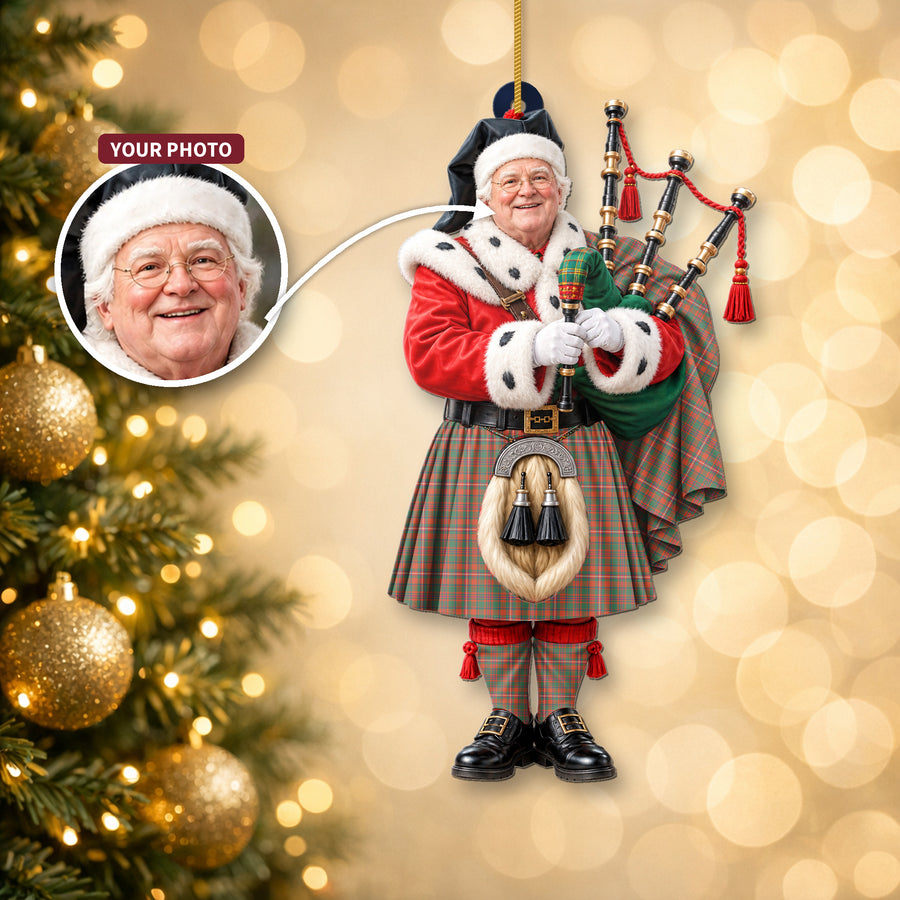 Christmas piper ornament in the MacKinnon Ancient tartan hanging on a Christmas tree, with the customer photo used for the face