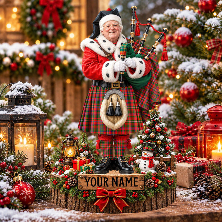 Personalized Christmas piper plaque in the MacKinnon Modern tartan, standing on a snowy log base with a name plaque
