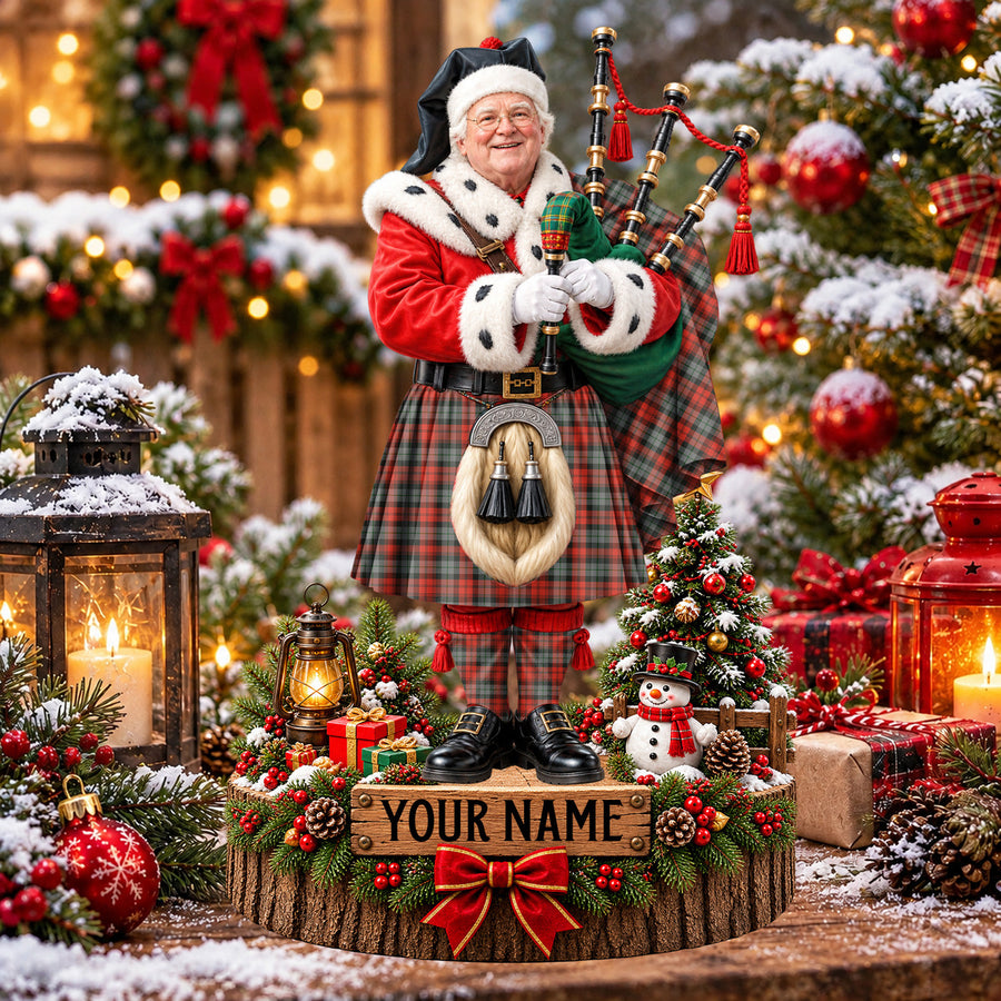 Personalized Christmas piper plaque in the MacLachlan Weathered tartan, standing on a snowy log base with a name plaque