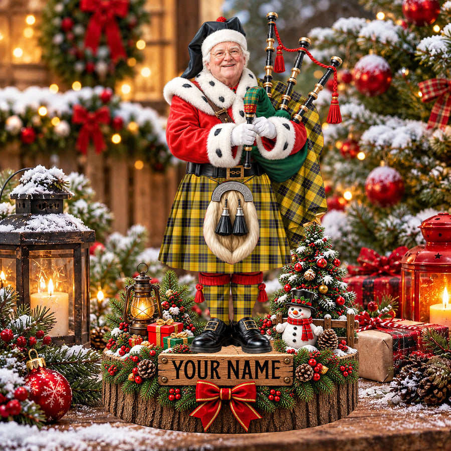 Personalized Christmas piper plaque in the MacLeod of Lewis Ancient tartan, standing on a snowy log base with a name plaque