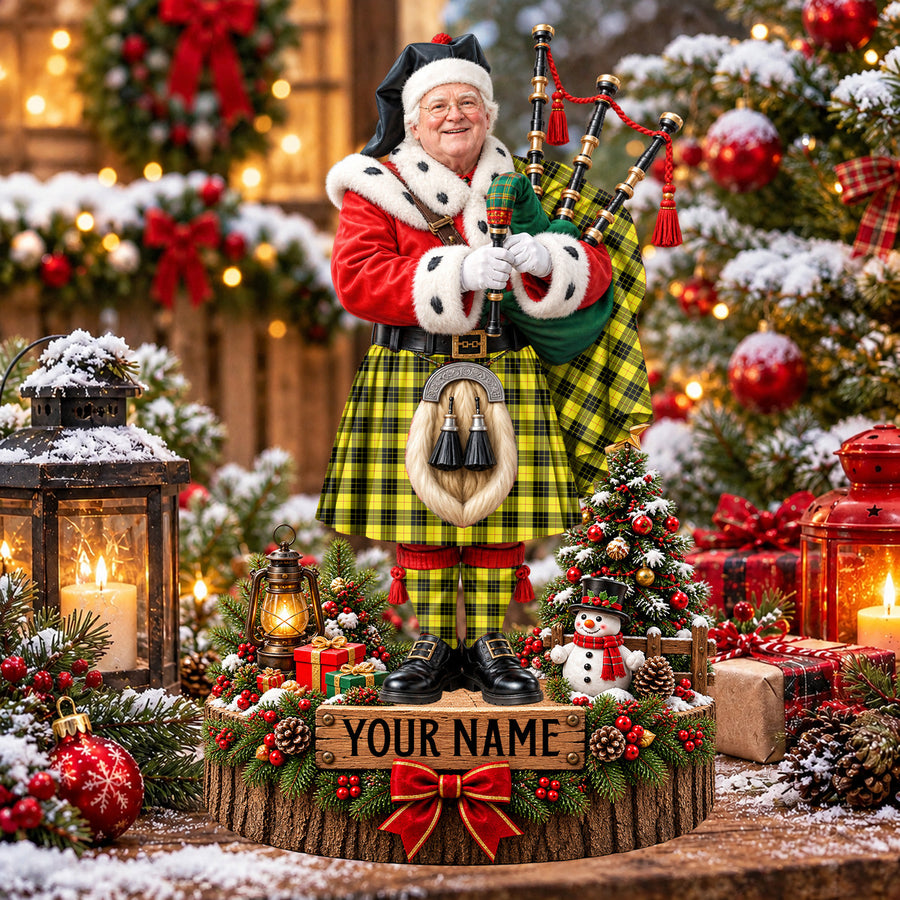 Personalized Christmas piper plaque in the MacLeod of Lewis Modern tartan, standing on a snowy log base with a name plaque