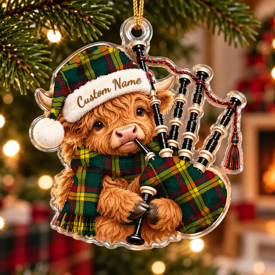Acrylic Highland cow calf ornament playing the bagpipes, in a MacMillan Old Modern tartan Santa hat, scarf and pipe bag, with a custom name on the hat