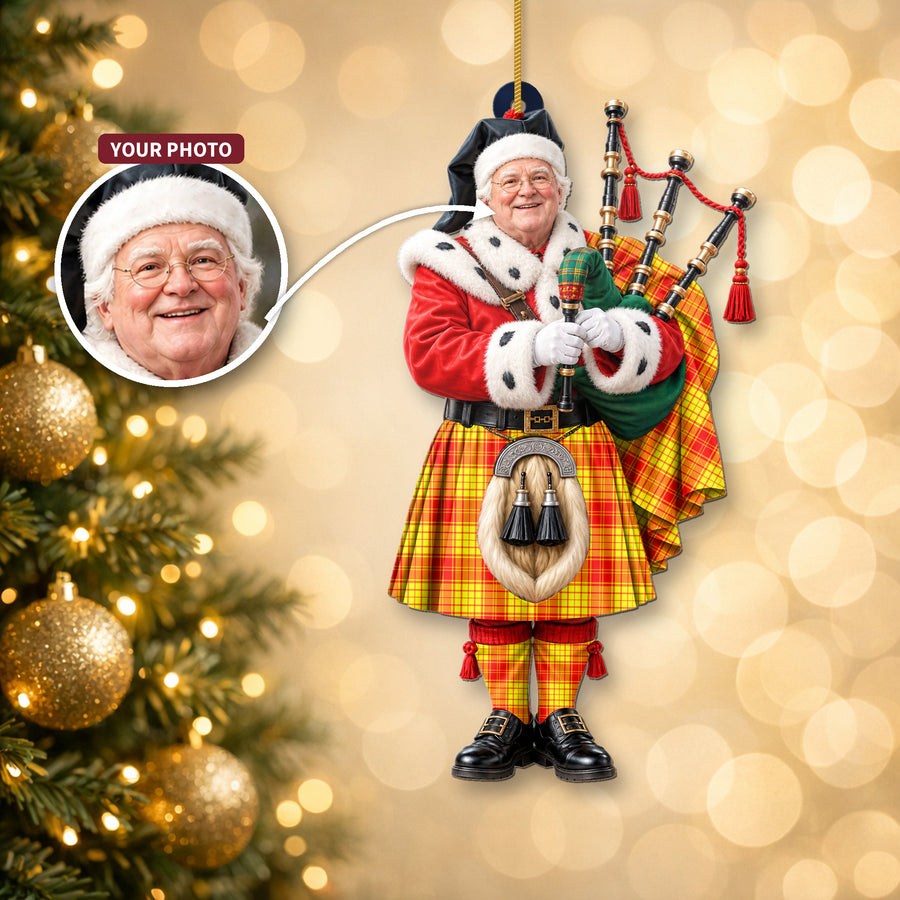 Christmas piper ornament in the MacMillan tartan hanging on a Christmas tree, with the customer photo used for the face