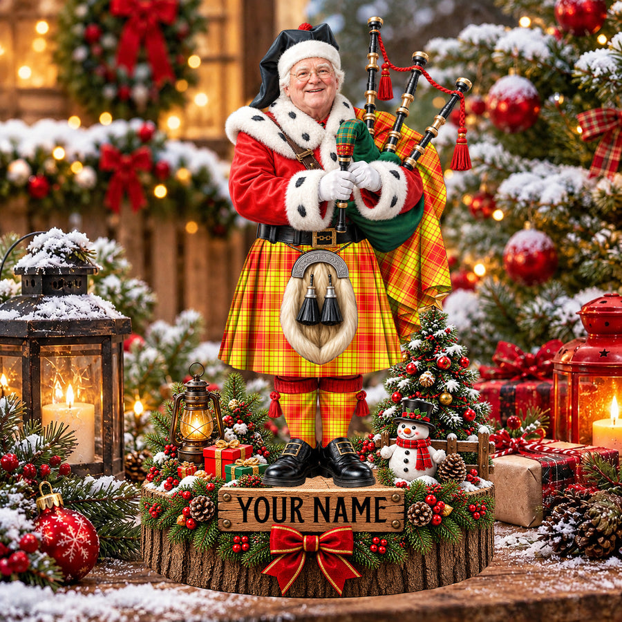Personalized Christmas piper plaque in the MacMillan tartan, standing on a snowy log base with a name plaque