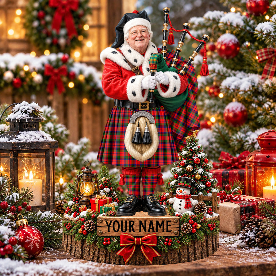 Personalized Christmas piper plaque in the MacNaughton Modern tartan, standing on a snowy log base with a name plaque
