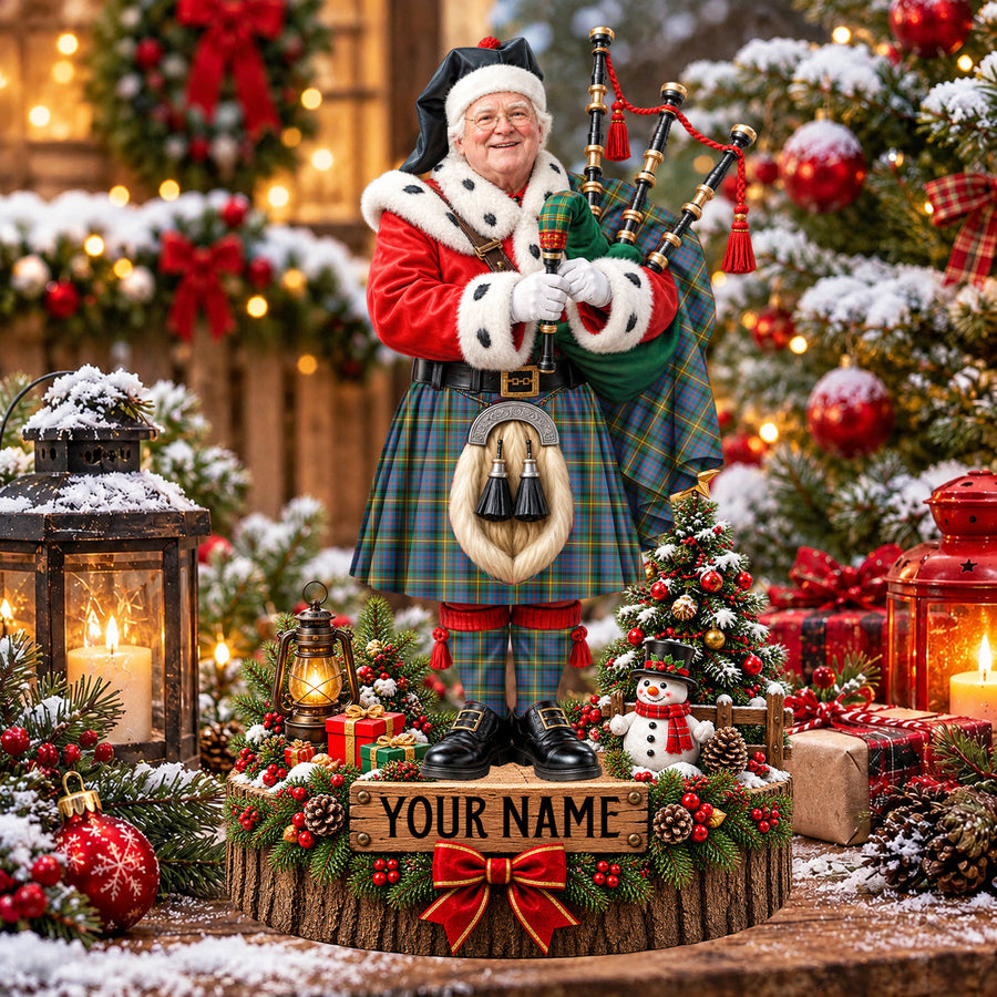 Personalized Christmas piper plaque in the MacSporran Ancient tartan, standing on a snowy log base with a name plaque