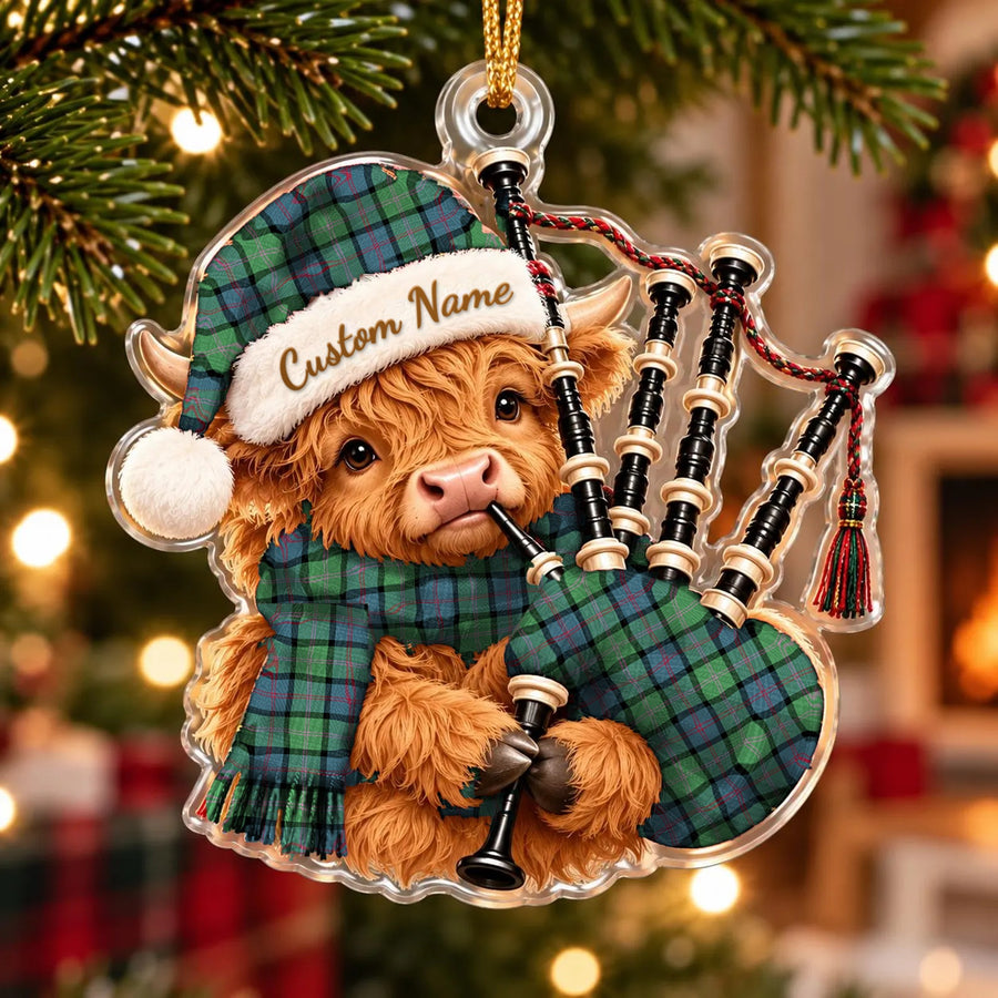 Acrylic Highland cow calf ornament playing the bagpipes, in a MacThomas Ancient tartan Santa hat, scarf and pipe bag, with a custom name on the hat