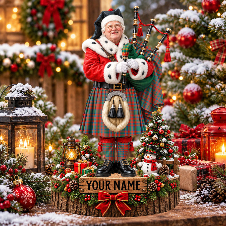 Personalized Christmas piper plaque in the Matheson Ancient tartan, standing on a snowy log base with a name plaque