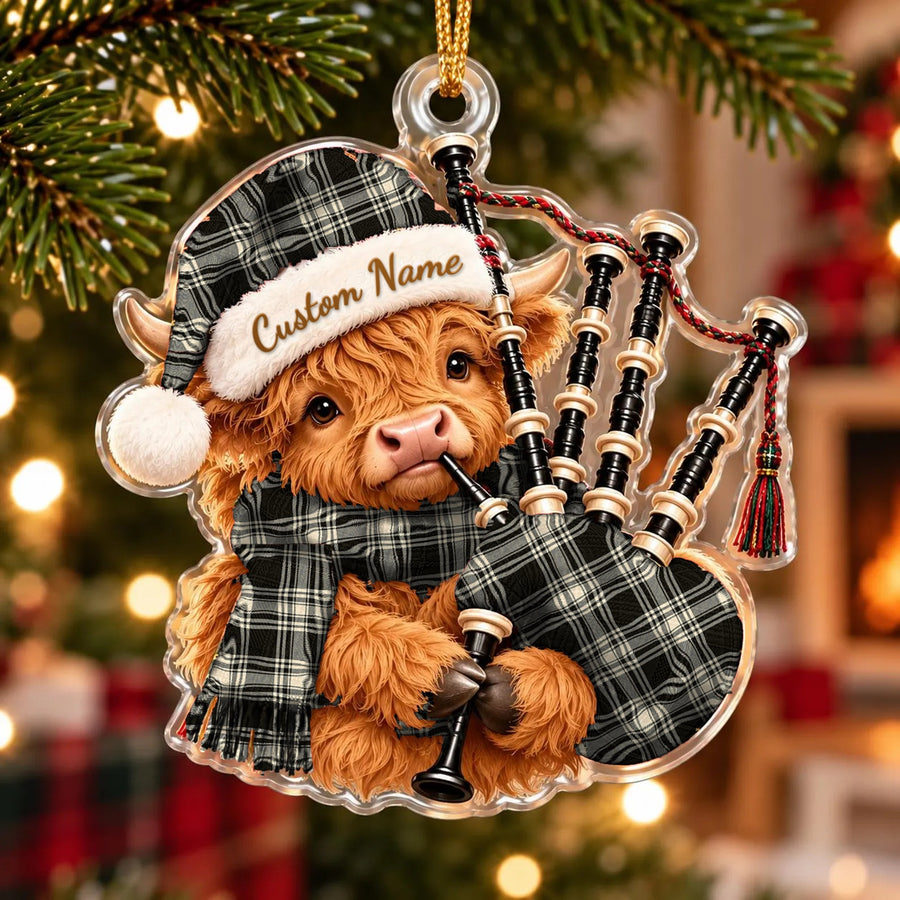 Acrylic Highland cow calf ornament playing the bagpipes, in a Menzies Black _ White Ancient tartan Santa hat, scarf and pipe bag, with a custom name on the hat