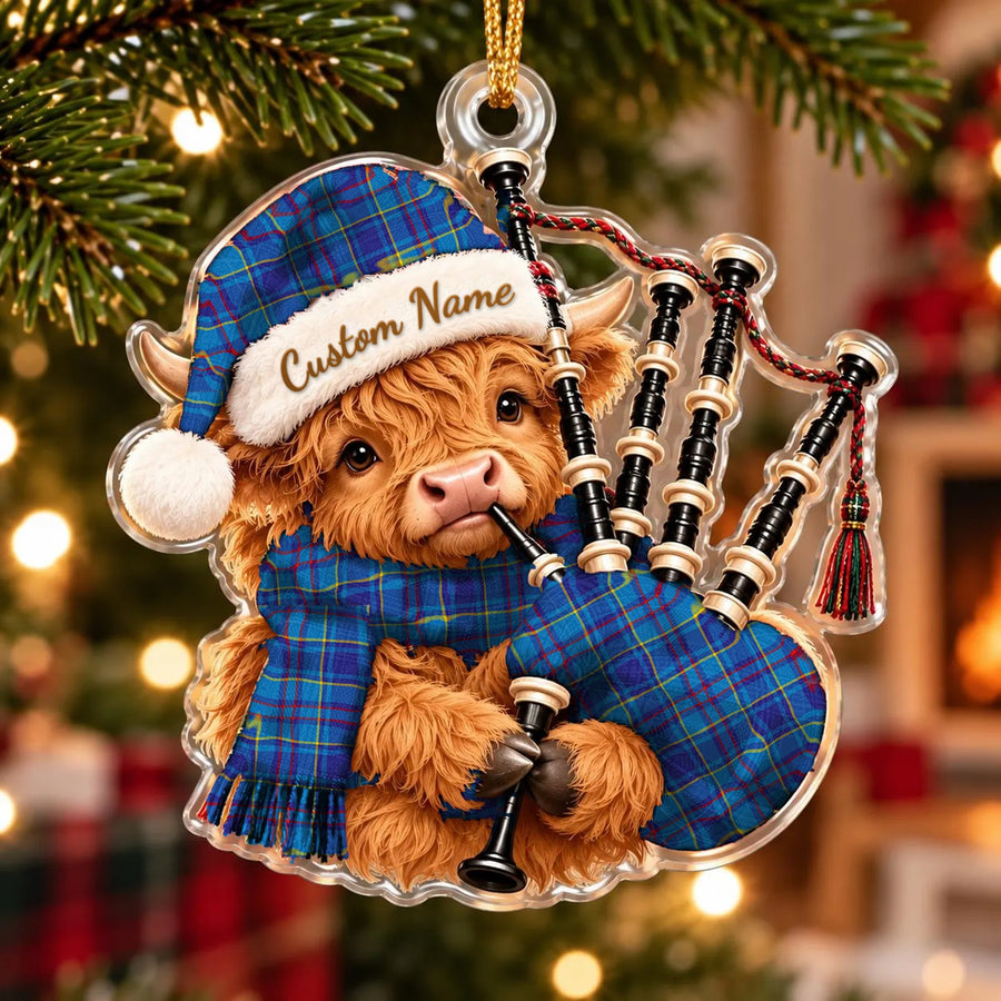 Acrylic Highland cow calf ornament playing the bagpipes, in a Mercer Modern tartan Santa hat, scarf and pipe bag, with a custom name on the hat