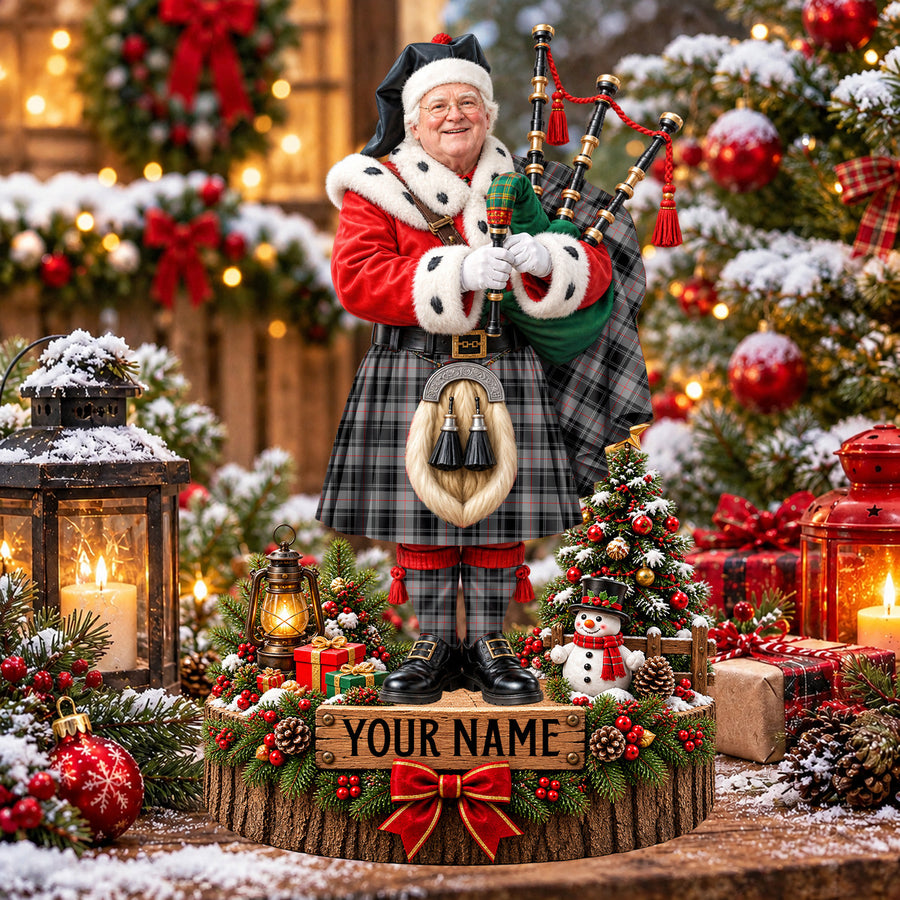 Personalized Christmas piper plaque in the Moffat Modern tartan, standing on a snowy log base with a name plaque