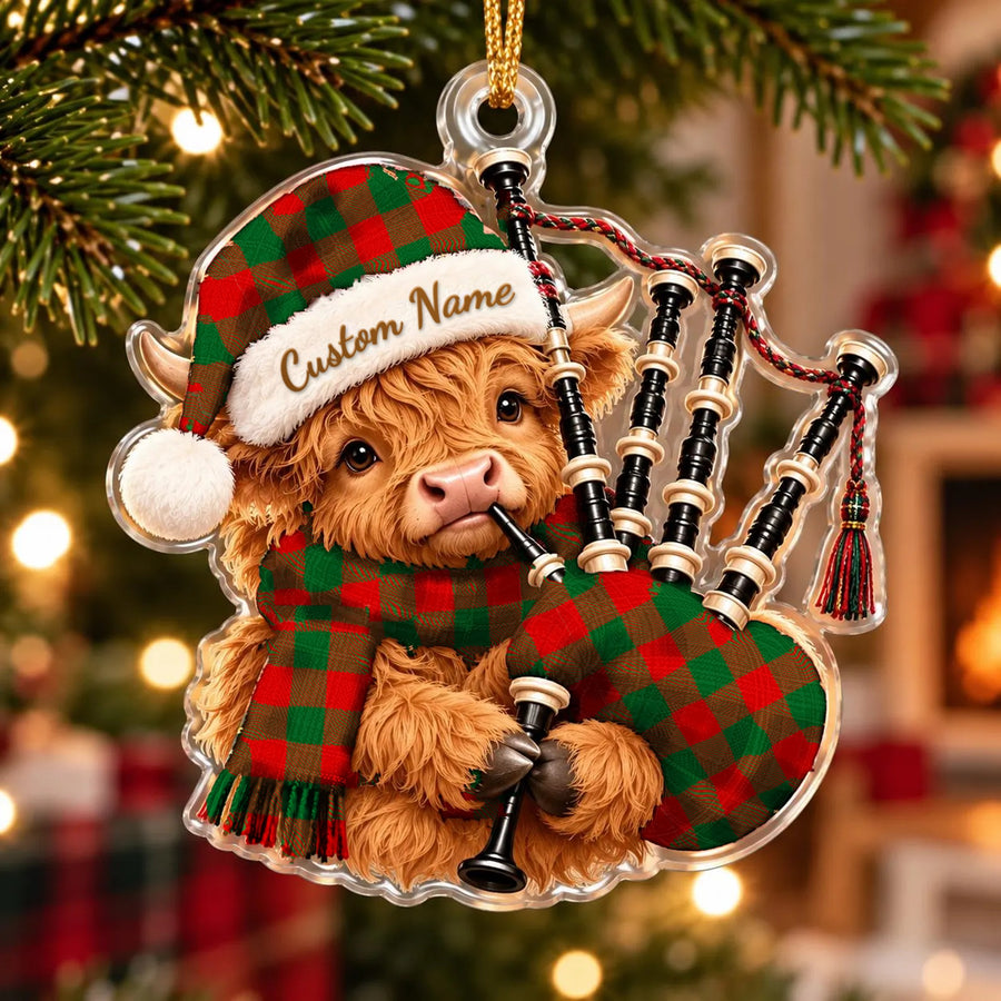 Acrylic Highland cow calf ornament playing the bagpipes, in a Moncrieffe tartan Santa hat, scarf and pipe bag, with a custom name on the hat