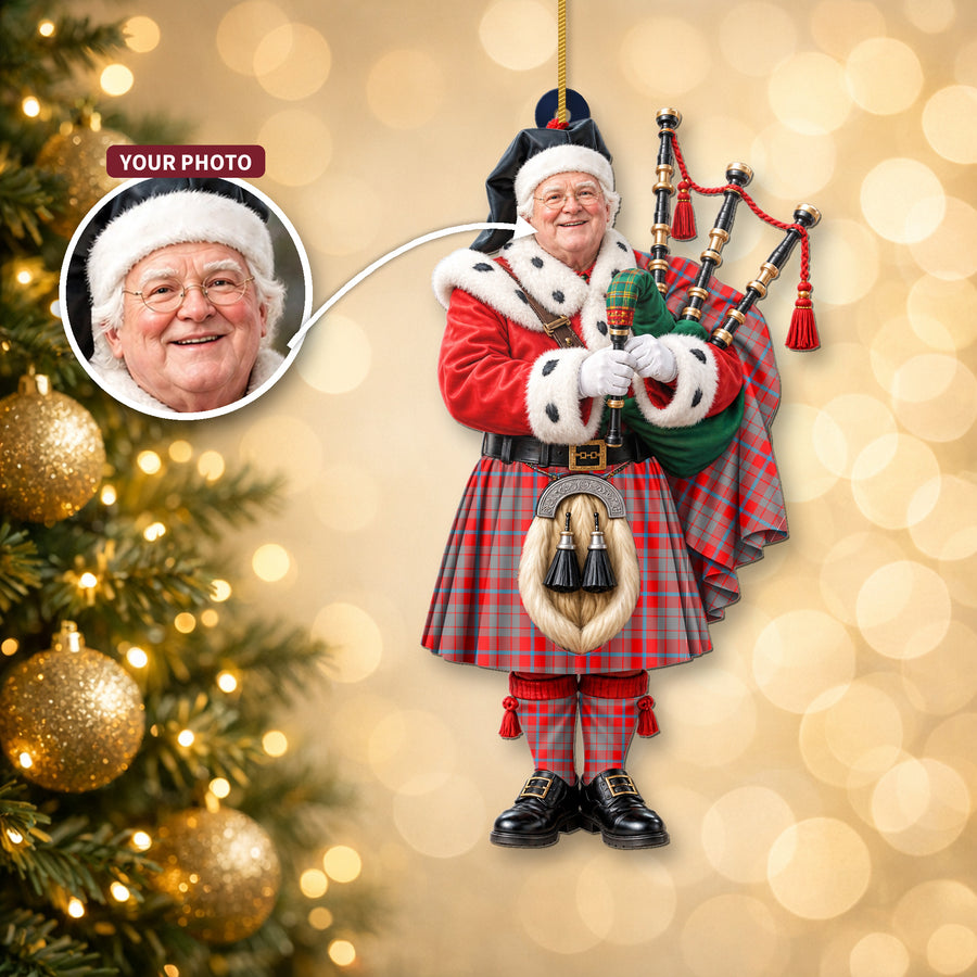 Christmas piper ornament in the Moubray tartan hanging on a Christmas tree, with the customer photo used for the face