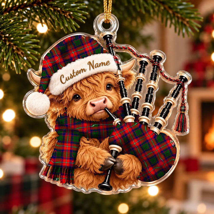 Acrylic Highland cow calf ornament playing the bagpipes, in a Mow (Roxburgh) tartan Santa hat, scarf and pipe bag, with a custom name on the hat