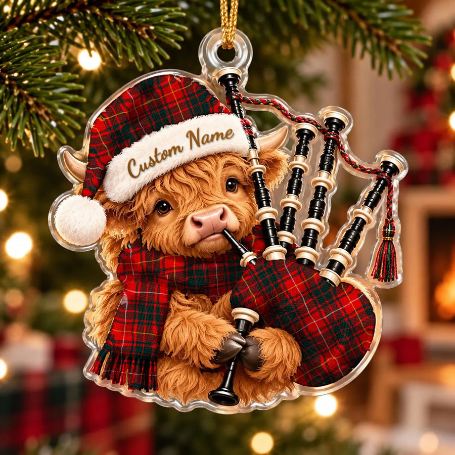 Acrylic Highland cow calf ornament playing the bagpipes, in a Munro Modern 1 tartan Santa hat, scarf and pipe bag, with a custom name on the hat