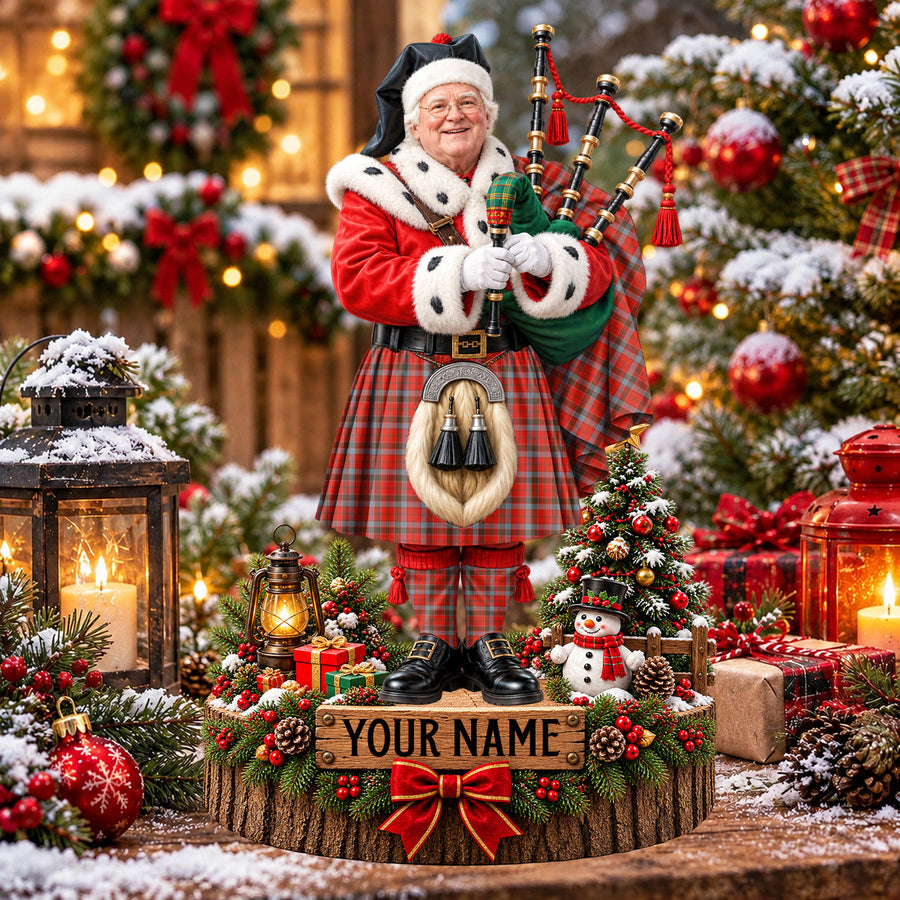 Personalized Christmas piper plaque in the Robertson Weathered tartan, standing on a snowy log base with a name plaque
