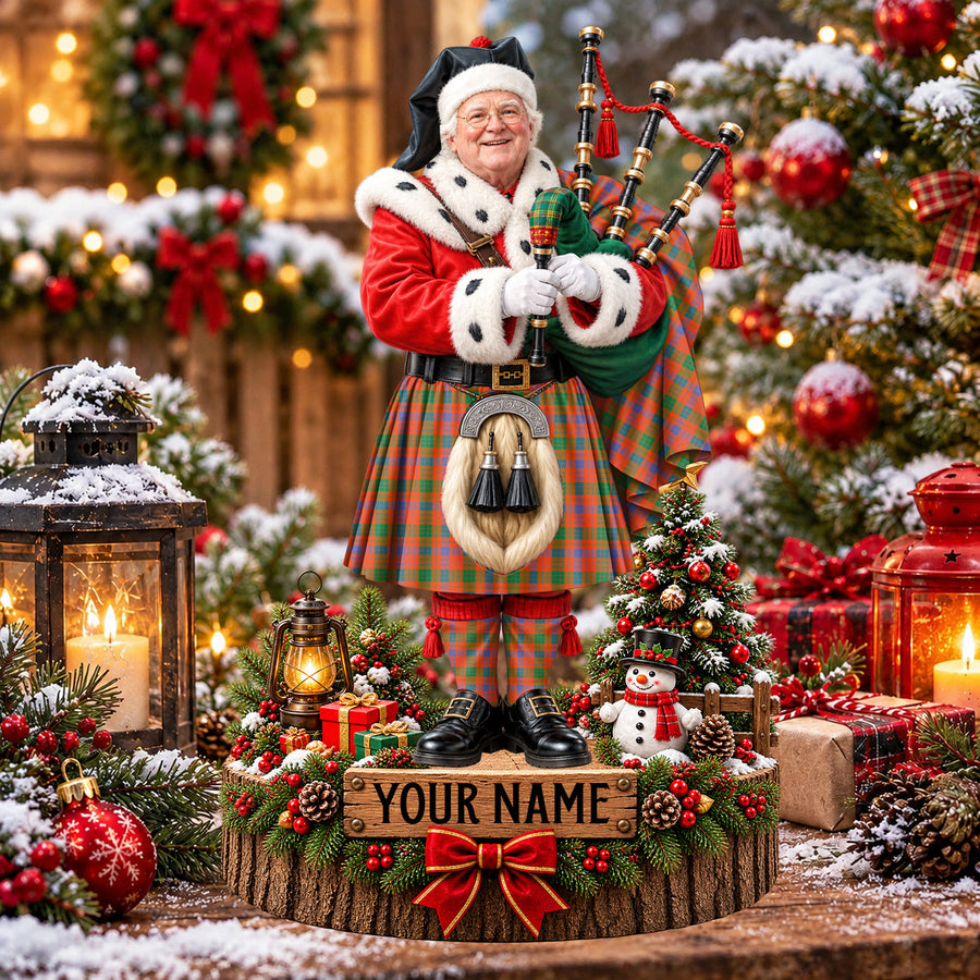Personalized Christmas piper plaque in the Ross Ancient tartan, standing on a snowy log base with a name plaque