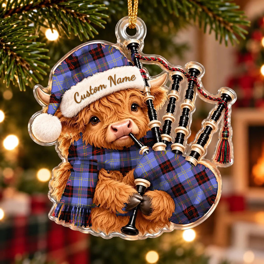 Acrylic Highland cow calf ornament playing the bagpipes, in a Rutherford tartan Santa hat, scarf and pipe bag, with a custom name on the hat