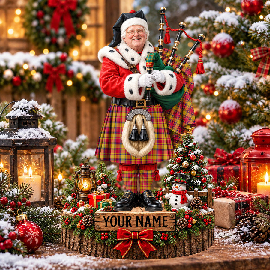 Personalized Christmas piper plaque in the Scrymgeour tartan, standing on a snowy log base with a name plaque