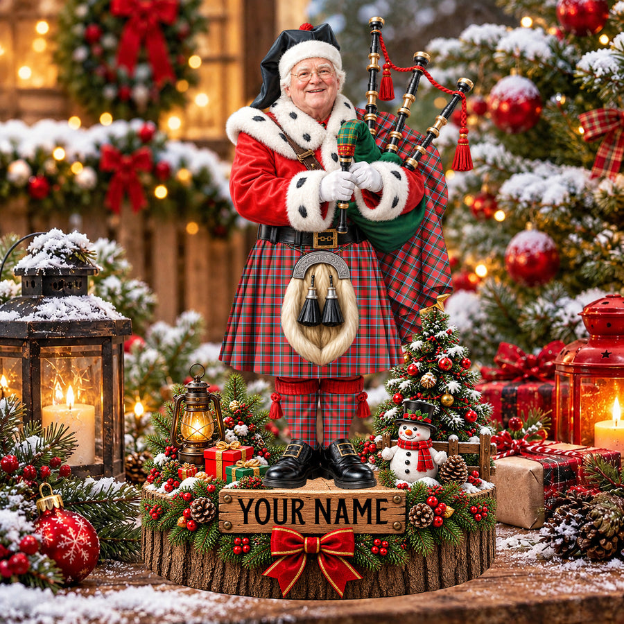 Personalized Christmas piper plaque in the Sinclair Modern tartan, standing on a snowy log base with a name plaque