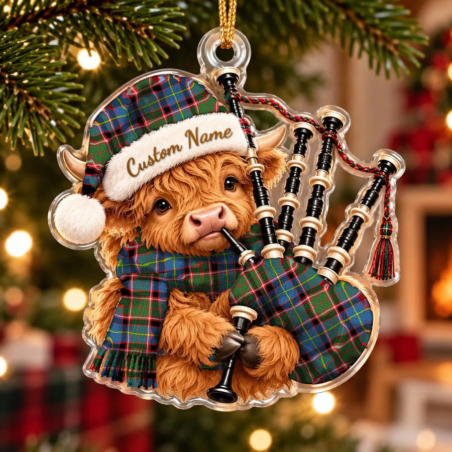 Acrylic Highland cow calf ornament playing the bagpipes, in a Stirling (of Keir) tartan Santa hat, scarf and pipe bag, with a custom name on the hat
