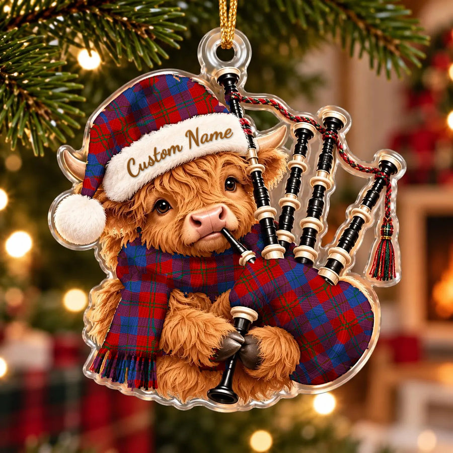 Acrylic Highland cow calf ornament playing the bagpipes, in a Witherspoon tartan Santa hat, scarf and pipe bag, with a custom name on the hat