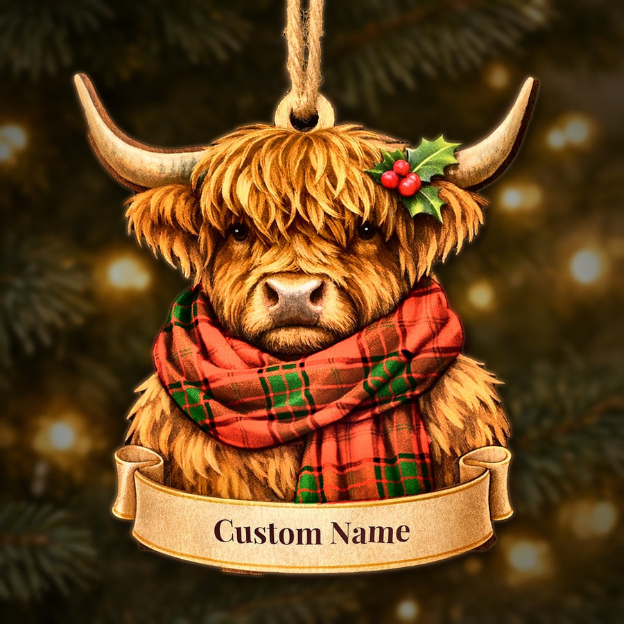 Wooden Highland cow Christmas ornament wearing a Adair tartan scarf, with a ribbon banner for a custom name