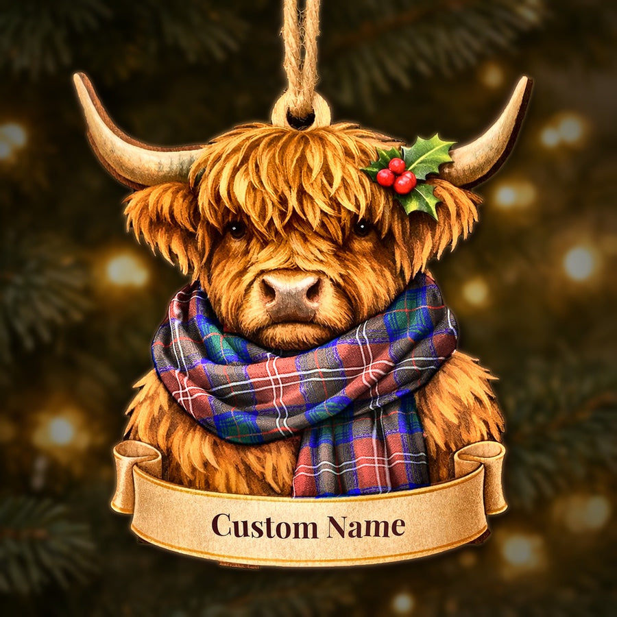 Wooden Highland cow Christmas ornament wearing a Chisholm Hunting Modern tartan scarf, with a ribbon banner for a custom name