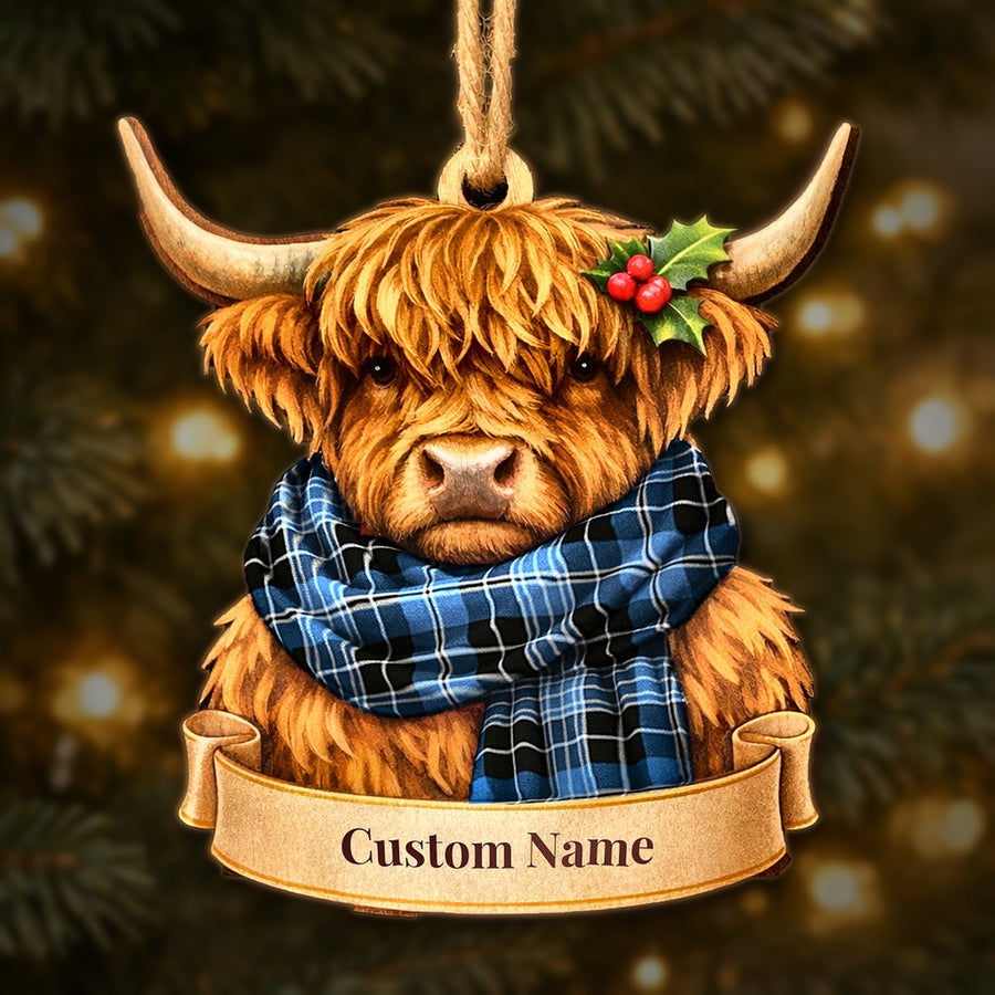 Wooden Highland cow Christmas ornament wearing a Clergy Blue tartan scarf, with a ribbon banner for a custom name